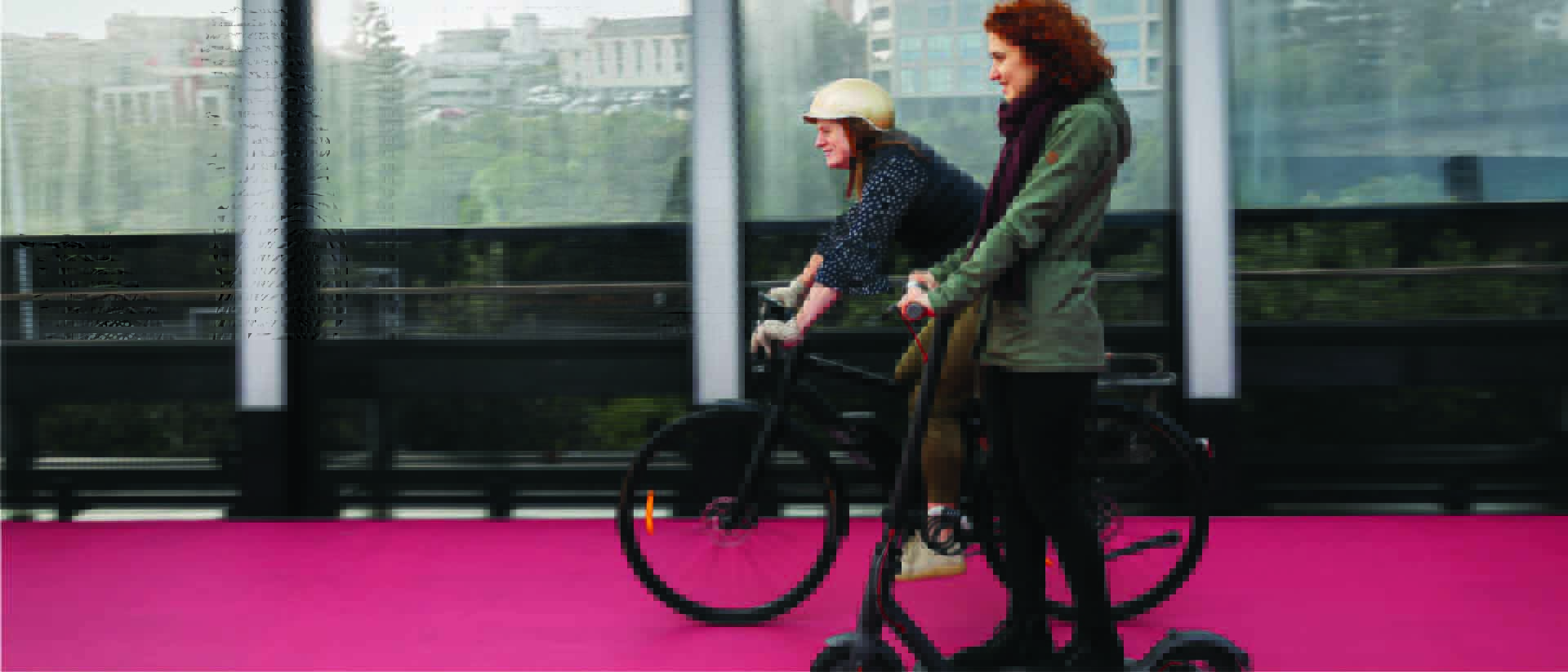 People riding electric biycles and electric scooters on Auckland lightpath.
