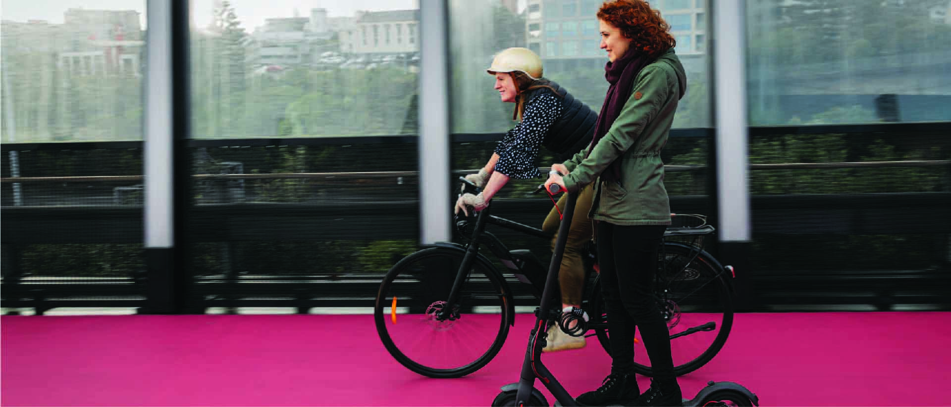 People riding electric biycles and electric scooters on Auckland lightpath.